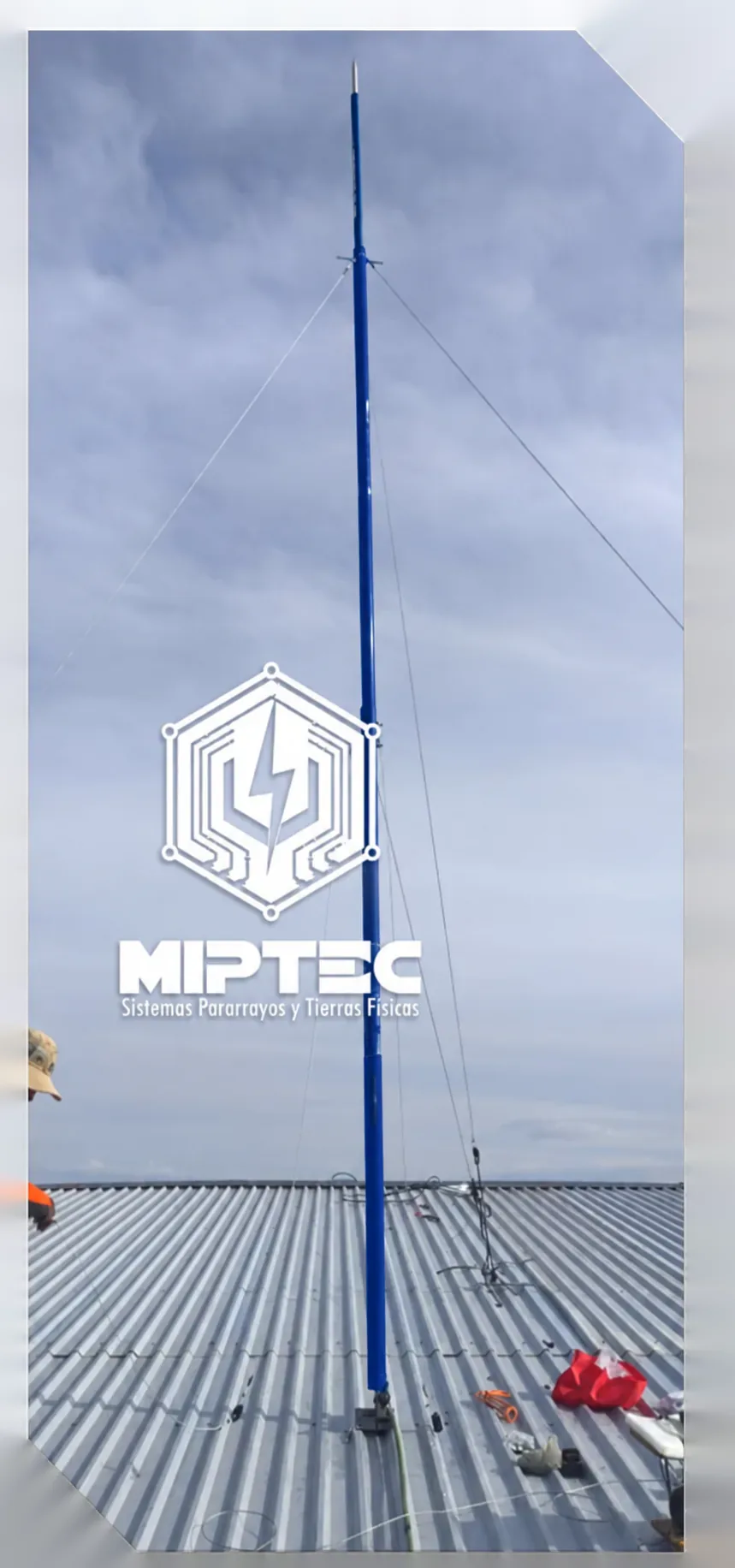 Mástil azul MIPTEC con punta pararrayos instalado sobre nave industrial